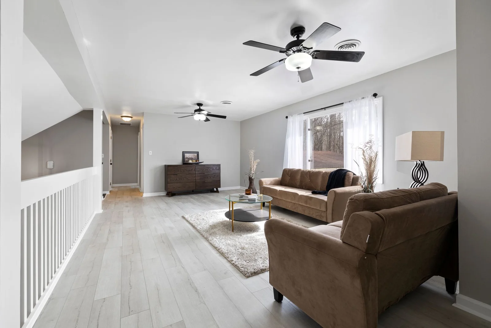 Lys stue med tregulv og store vinduer etter renovering